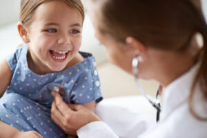 Nurse listens to young child's lungs with stethoscope
